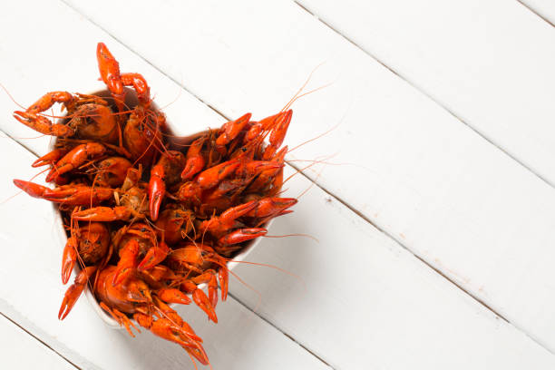 gotowane raki w misce w kształcie serca na białym tle - crayfish new orleans cajun food louisiana zdjęcia i obrazy z banku zdjęć