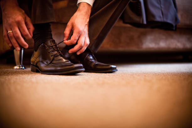 istock groom business man puts on shoes 1125140819