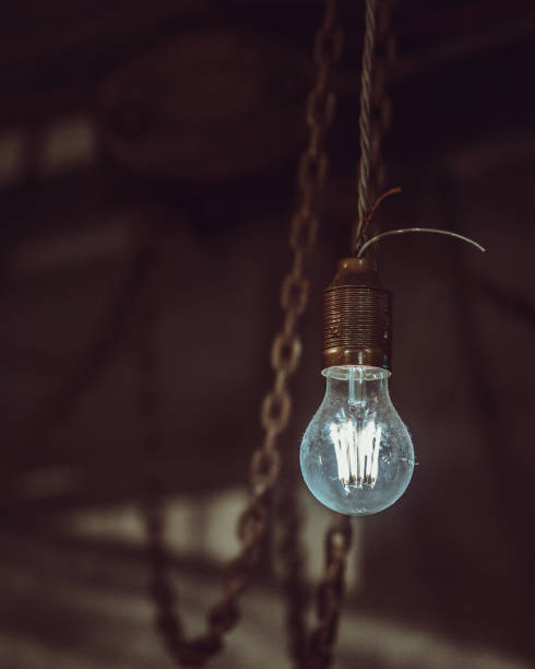 istock Old dusty light bulb glowing in the dark. 1125156265