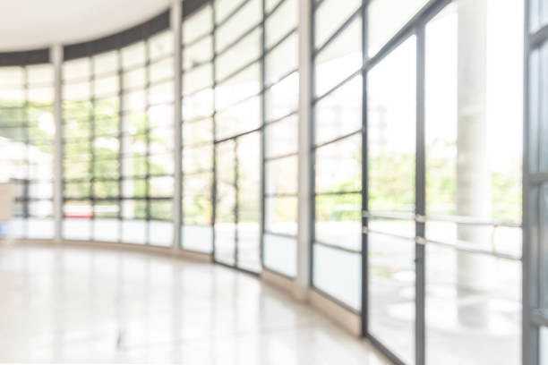 istock Blur background interior view looking out toward to empty office lobby and entrance doors and glass curtain wall 1125176569