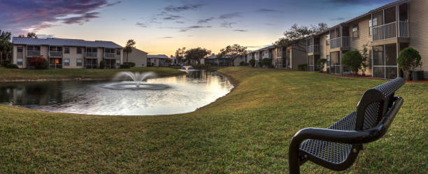 istock Bench overlooking a large pond with a fountain at sunset 1125180718