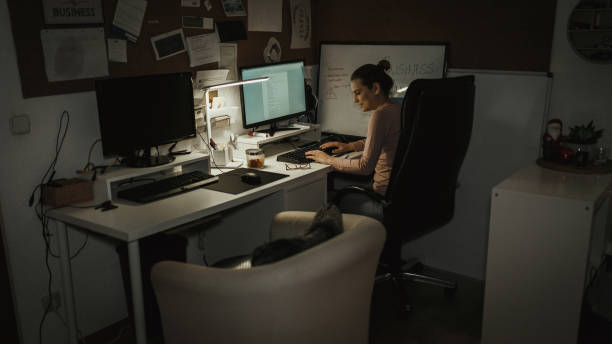istock Smiling woman working late and using computer at the home office 1125184003
