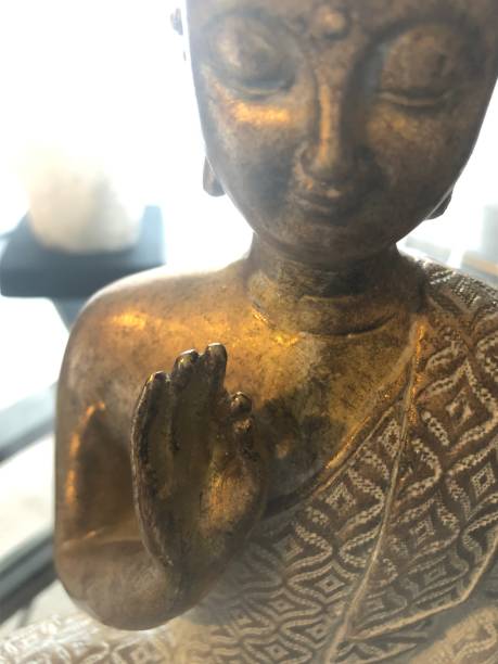 istock Gold coloured Sitting Buddha Meditating with Daylight in Background 1125188596