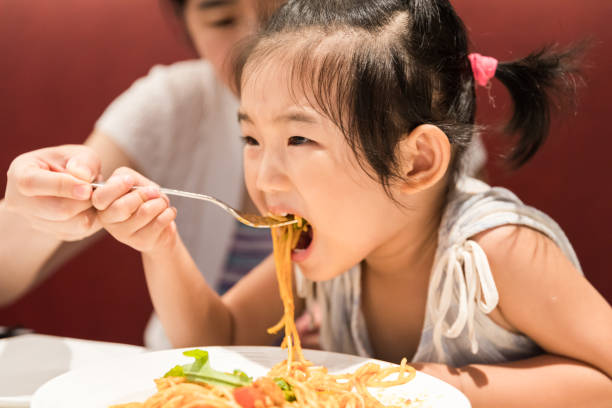 istock Cute baby girl eating spaghetti 1125194199