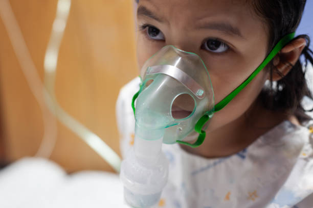 Asian child girl has asthma or pneumonia disease and need nebulization by get inhaler mask on her face Asian child girl has asthma or pneumonia disease and need nebulization by get inhaler mask on her face pediatric nebulizer mask stock pictures, royalty-free photos & images