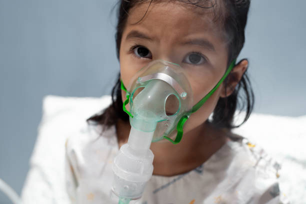 Asian child girl has asthma or pneumonia disease and need nebulization by get inhaler mask on her face Asian child girl has asthma or pneumonia disease and need nebulization by get inhaler mask on her face pediatric nebulizer mask stock pictures, royalty-free photos & images