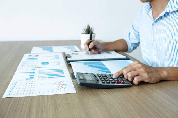 istock Businessman accountant making working audit and calculating expense financial annual financial report balance sheet statement, doing finance making notes on paper checking inspection 1125210383