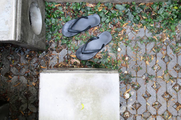 istock black sandals on cement blocks texture with little dried leaf in the backyard 1125212598
