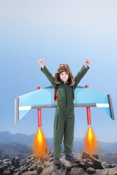 istock Boy standing with his arms up in the air 1125213697