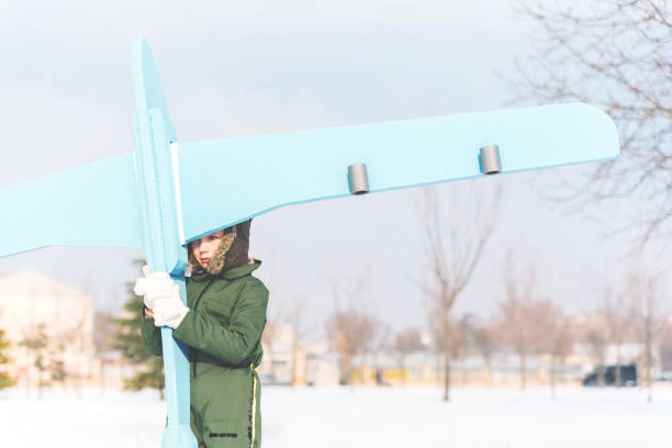 dziecko przewożące zabawkę samolotową - playground snow winter little girls zdjęcia i obrazy z banku zdjęć