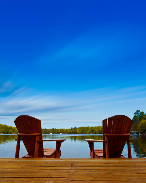 istock Adirondack chairs sit on a wooden dock 1125219738