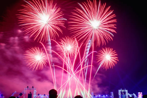 istock Crowd watching fireworks and celebrating city founded. Beautiful colorful fireworks display in the urban for celebration on dark night background. Red tone light. 1125223587