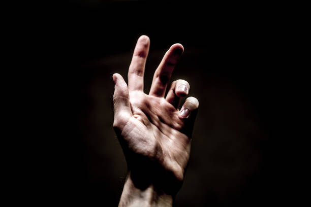 istock hand stretches up to the light on a dark background 1125235876