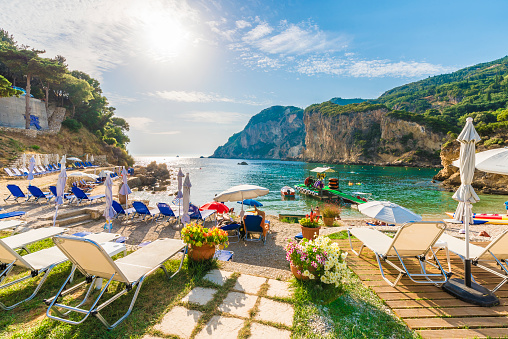 Sunbeds and umbrella on the beach in Corfu Island, Greece.