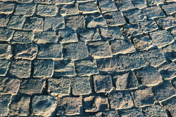 Surface of textured grey cobbled European street as background, for decoration
