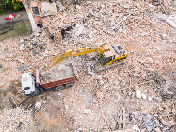istock yellow excavator loading a dump truck with debris and trash after building demolition 1125255665