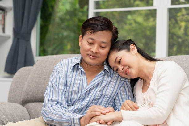 istock Romantic senior couple sitting together on sofa at home 1125259020