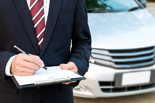 An insurance expert employee working with a car at the outdoor