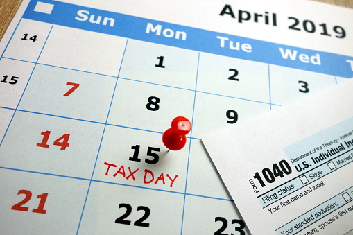 Tax day marked on April 2019 monthly calendar with 1040 form