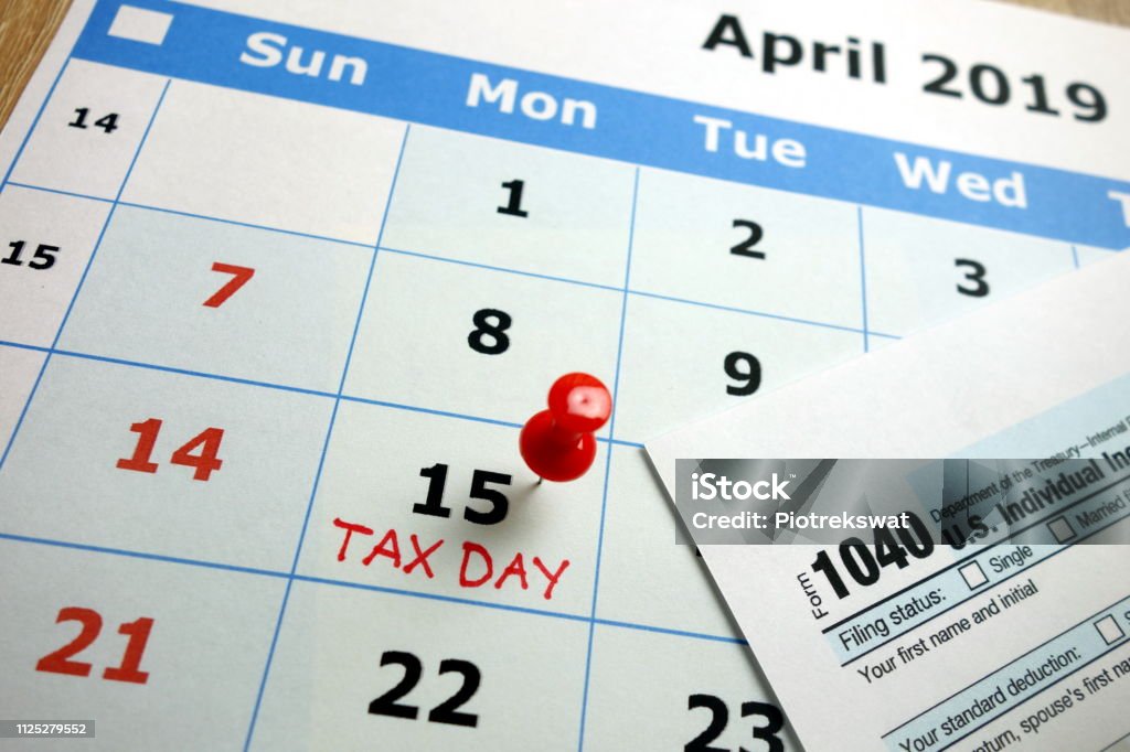 Tax day 2019 Tax day marked on April 2019 monthly calendar with 1040 form Tax Form Stock Photo