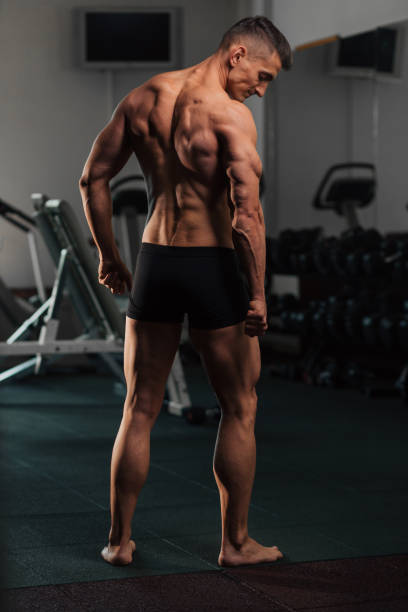 istock Young fit man doing bodybuilding competition poses 1125283216