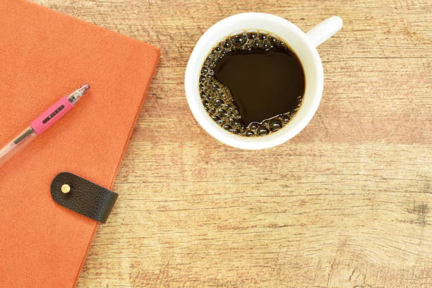 diary book and pen with coffee on table diary book and pen with black coffee cup on wooden table diary lock book cover book stock pictures, royalty-free photos & images