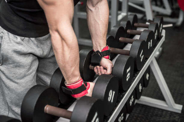 istock Male hands with dumbbells in gym closeup 1125285520
