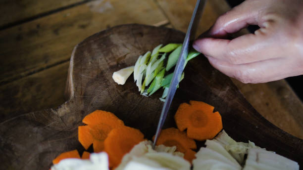 istock hand with knife cuts green onions 1125285850