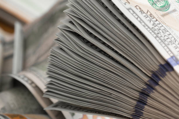 istock Stack of one hundred dollar bills on a wooden table 1125285882