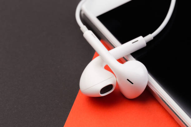 istock white earphones with phone on black  and red background 1125286212