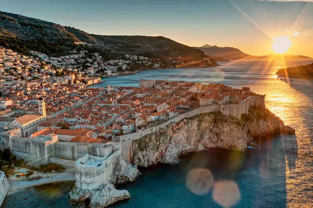Photo shows beautiful sunrise at Dubrovnik old town. Photo also shows the blue sea and old town wall where the sunlights turned the town in golden color.