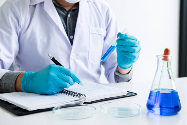 istock Biochemistry laboratory research, Chemist is analyzing sample in laboratory with equipment and science experiments glassware containing chemical liquid 1125288458