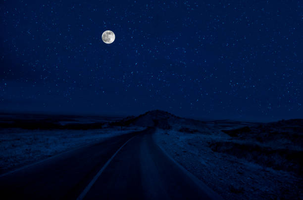 Mountain Road through the forest on a full moon night. Scenic night landscape of dark blue sky with moon. Azerbaijan stock photo