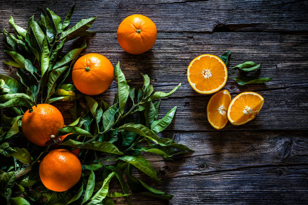 オレンジ色の果実とオレンジの支店が素朴な木製のテーブルで撮影 - tangerine citrus fruit organic orange ストックフォトと画像