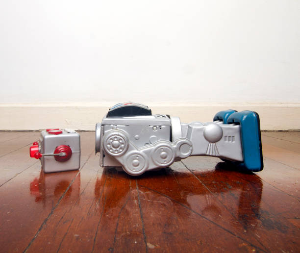 big siver robot has lst his head on a old wooden floor