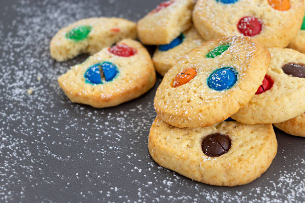 istock Homemade shortbread cookies with multicolored chocolate chips and icing powdered on gray background. Selective focus. Christmas concept. Copy space. 1125300130