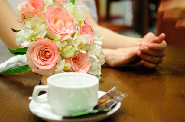 istock A beautiful bouquet, women's hands and a tea cup on the table. 1125301490
