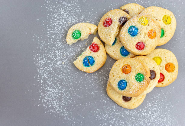 istock Homemade shortbread cookies with multicolored chocolate chips and icing powdered on gray background. Selective focus. Christmas concept. Copy space. Top view. 1125301894