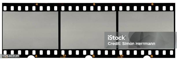 Long Film Strip Blank Photo Frames Free Space For Your Pictures Real Highres 35mm Film Strip Scan With Signs Of Usage On White Background Stock Photo - Download Image Now