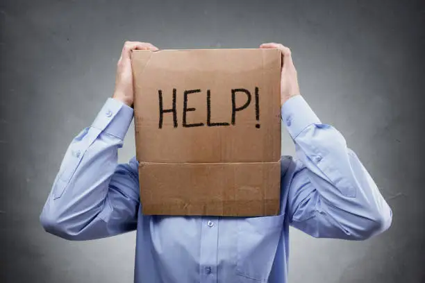 Photo of Cardboard box on businessman head ask for help