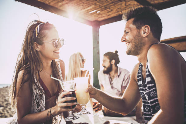 istock Happy couple talking while toasting with cocktails in summer day. 1125306756