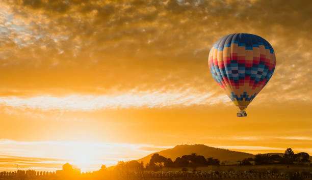 globo de aire caliente vuelan al amanecer amarillo - heat mid air flying float fotografías e imágenes de stock