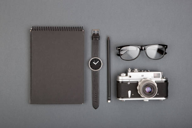 istock Journalist or blogger table - spiral blank notebook, pencil, camera and glasses on gray background, top view 1125312685