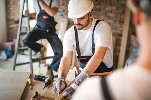 istock Young manual worker drawing measurements on a plank at construction site. 1125313126
