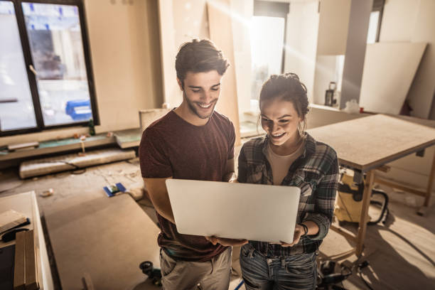 istock Happy couple using laptop while being on construction site in their apartment. 1125313788