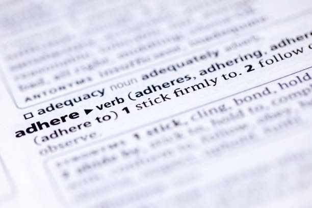 istock Close up to the dictionary definition of word Adhere 1125314516