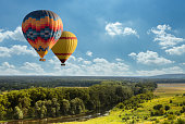 Colorful hot air balloon flying over green field