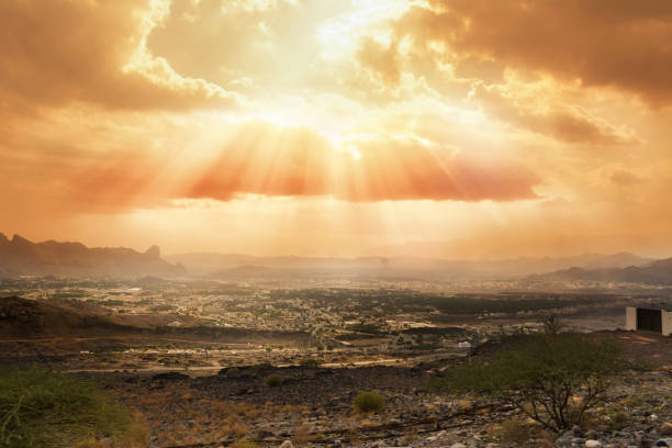 Cloudy sky slashed by the sun's rays over the village of Al Hamra (Oman)