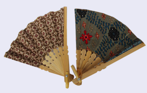 istock A wooden hand fan in Javanese cloth called batik. 1125325238