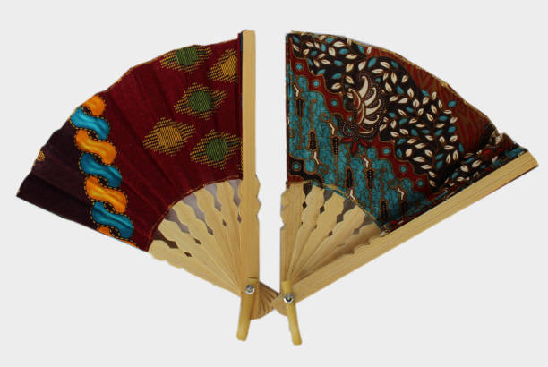 istock A wooden hand fan in Javanese cloth called batik. 1125325239